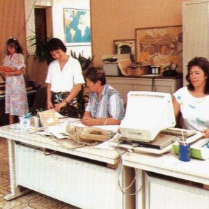 Annick Garnier à son bureau et d'autres employés de l'année 1988
